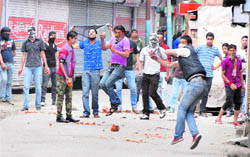 Youths throw stones towards police personnel during a clash that followed the arrest of JKLF chief Yasin Malik at Maisuma in Srinagar on Thursday. 
