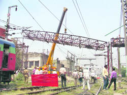 A crane removes a span of the 105-year-old Lakkar Bridge in Ludhiana on Thursday
