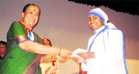 Uttarakhand Governor Margaret Alva presents a cheque to a nun belonging to a voluntary organisation at a function in Dehradun on Saturday.