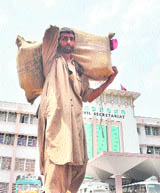 A porter in Jammu carries official records to be shifted to Srinagar in view of the Darbar Move on Saturday.