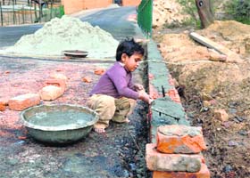 CHILD LABOUR AT WORK: A kid busy in construction work on Labour Day near Surajkund in Faridabad on Sunday