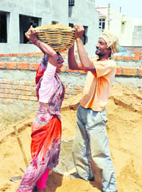 Labourers work at a construction site on International Labour Day in Jammu on Sunday. 