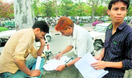 Thakur Dass (centre) while checking a clients form for a new ration card in front of the UT food & supply departmen; and (right) Pyare Prasad (right) fills out a form of one of his clients in Sector 17.