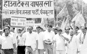 BJP activists take out a protest rally at Sector 1 in Panchkula on Monday.