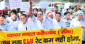 Owners of houses and shops hold a protest march in Faridabad on Monday. 