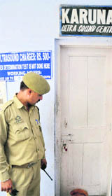 A policeman looks at an ultrasound clinic that was sealed by Health Department officials in Jammu