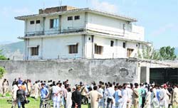 Pakistani mediapersons and residents gather outside the hideout of Al-Qaida boss Osama bin Laden in Abbottabad 