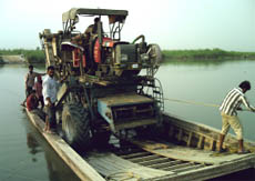 Farmers transporting a combine harvester in a boat across the Sutlej in the DT Mal area to harvest the wheat crop. 