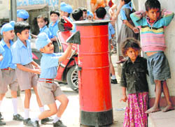 THE GREAT DIVIDE: Students of Lawrence Public Senior Secondary School, Mohali, post cards to their mothers for the Mothers Day, while deprived children stand unconcerned.