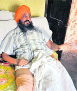 Newly-elected sarpanch Rabinder Singh Binder lies on a bed at his house in the RS Pura sector in Jammu