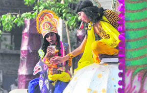 A child dressed up for a tableau sips water during a procession on the eve of Parshuram Jayanti in Ludhiana