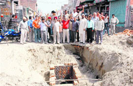 Residents of the Chander Nagar locality protest against the slow pace of laying new sewerage lines in Ludhiana