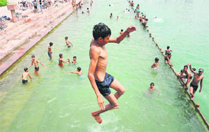 Children take a dip into Brahmasarovar on a hot afternoon in Kurukshetra.