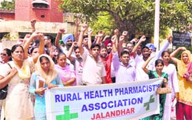 Members of the Rural Health Pharmacists Association raise slogans against the government in Jalandhar