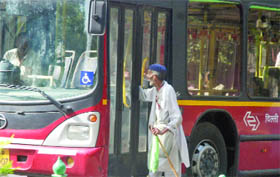The hand of an old man gets stuck in the bus door as the driver inadvertently closes the door at Tilak Marg bus stand in New Delhi on Friday. 
