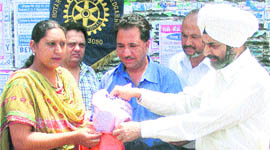 Rotarians distribute cloth bags among shoppers at Ahmedgarh.
