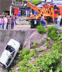 A car that fell down the Santoshi Mata bridge being extracted by a recovery van