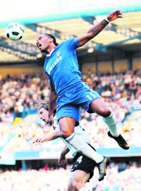 Chelsea's Didier Drogba leaps above Tottenham Hotspur's Luka Modric during their EPL match at Stamford Bridge in London