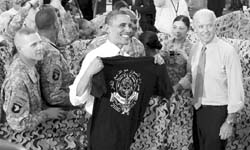 President Barack Obama displays a shirt given to him by troops as Vice-President Joe Biden is seen at right after they spoke to military personnel who have recently returned from Afghanistan and played role in Operation Geronimo. 
