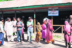 People outside a polling station during phase seven of the panchayat elections at Sombrun village in Shangus block on Sunday