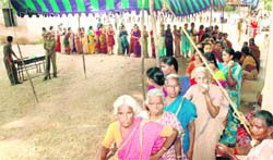 Voters in a queue to cast their votes at a polling booth during the by-election in Kadapa district of Andhra Pradesh 