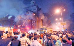 Egyptians gather as firefighters extinguish flames at the church in Cairo