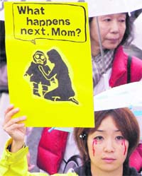 A protester holds a placard with an anti-nuclear slogan 
