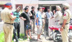 Police officials check identity documents of occupants of a paying guest house at Phase 4, Mohali,