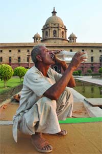 A labourer quenches his thirst at the Rajpath in New Delhi as the mercury shoots up on Monday