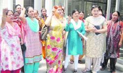Women hold a demonstration in front of the office of the Dehradun SSP