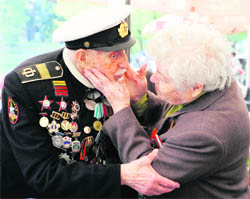 A woman kisses a Russian WW II veteran as they celebrate Victory Day in a park to commemorate <p>the end of WW II in Moscow on Monday.  AFP