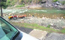 A tractor engaged in illegal mining from the Tirthan, near Dhaman