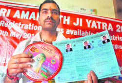 Ujwal Sharma shows the first registration slip of the Amarnath yatra at the J&K Bank registration counter in Jammu on Tuesday