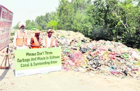 Labourers deployed by the Lets Clean Ludhiana Foundation at Sidhwan Canal to remove garbage