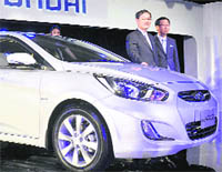 President & CEO, Hyundai Motors, SS Yang and MD & CEO HMIL, HW Park (R) along with a model pose with Fluidic Verna at its launch in New Delhi on Wednesday. 