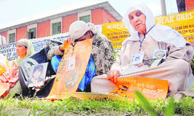 Relatives of the missing persons hold placards during a sit-in protest in Srinagar.