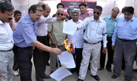 Entrepreneurs burn copies of Haryana government's new industrial policy and HSIIDC's estate management procedure (EMP-2011) at a protest demonstration in Gurgaon on Thursday.