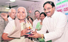 Chief Minister Ramesh Pokhriyal Nishank honours a retired nurse at a function held on the occasion of International Nurses Day in Dehradun on Thursday. 