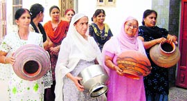 Women show empty pitchers in ward No. 9 of Fatehabad on Thursday.
