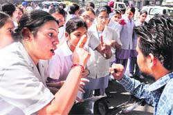 A nursing student argues with a motorcyclist during the protest by interns of BL Memorial Kapoor Hospital in Ludhiana