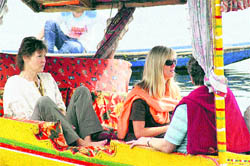 Foreign tourists enjoy a shikara ride in Dal Lake in Srinagar on Friday