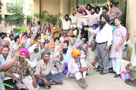 Riot victims led by activists of the Danga Peerit Welfare Society stage a dharna outside the GLADA office in Ludhiana on Friday.