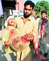 A man carries an injured blast victim to hospital in Peshawar on Friday