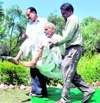 An elderly man is brought to a government function to get his old-age pension at Gandhi Park, Dehradun, on Saturday.