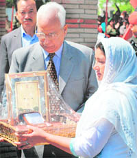 Governor NN Vohra presents an award to a widow during an Army Mela in Srinagar