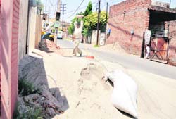 A view of construction material dumped in the middle of a road in Ludhiana.