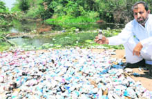  A resident of Kaimbwala village shows the littered bottles of syrups and medicines in the choe. 