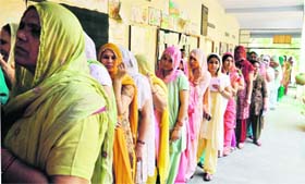 Women wait for their turn to cast their vote during the MCG elections at Shukrali in Gurgaon on Sunday