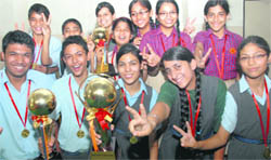 Winners strike a pose with their trophies after winning Shri Hans Raj Sharma Memorial Inter-School Carrom Tournament in Mohali on Monday.