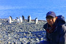 Aman Malik poses with penguins in Antarctica